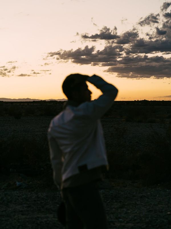Silhouette of a man in a meditative pose against a sunrise.